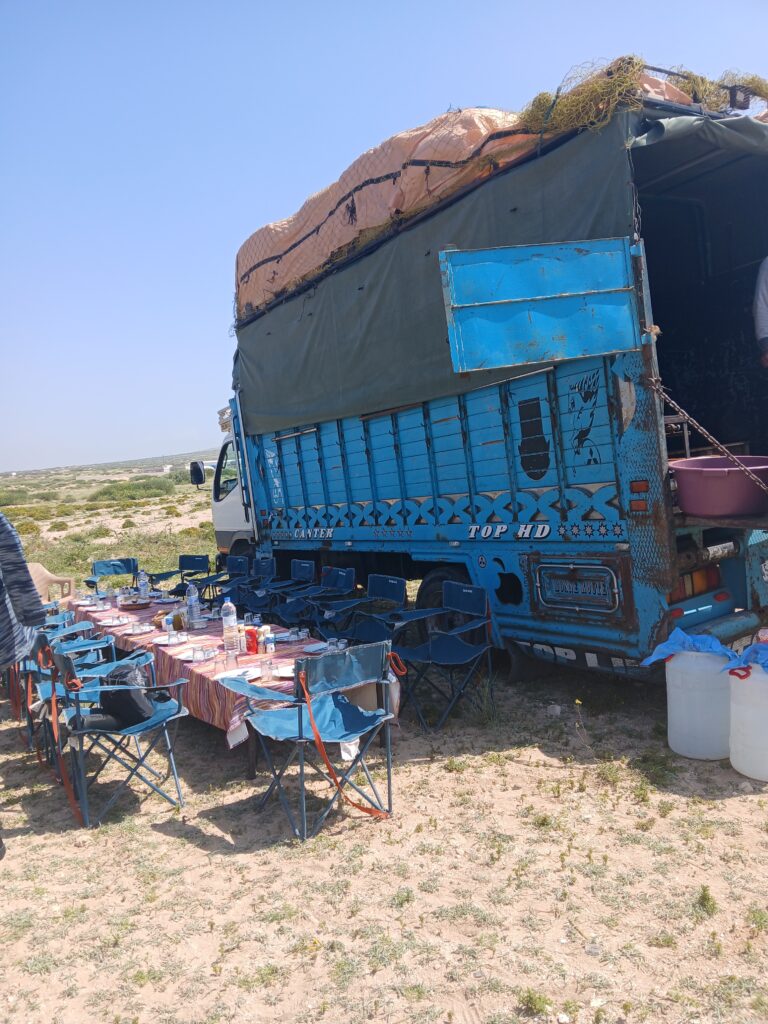 A lunch table next to a blue transport truck